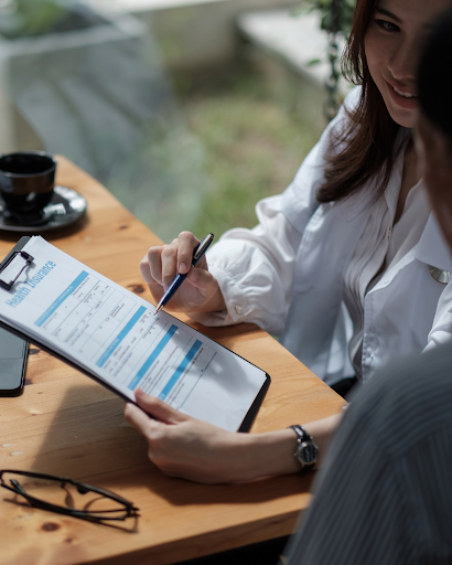 Insurance agent explaining policy details to a new client in an office setting