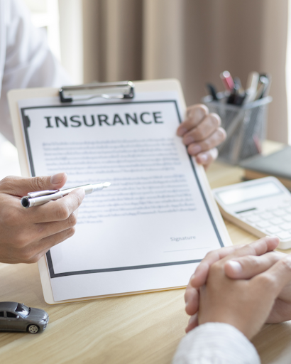 Insurance agent helping a customer understand their insurance policy documents in an office setting.