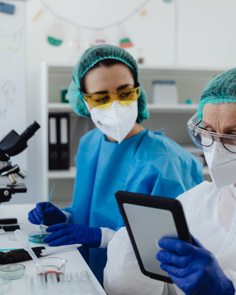 Two female scientists reviewing lab data while performing a lab test.