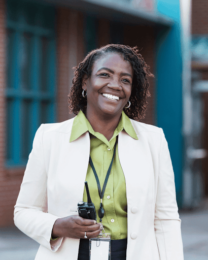 School administrator standing outside a school building.